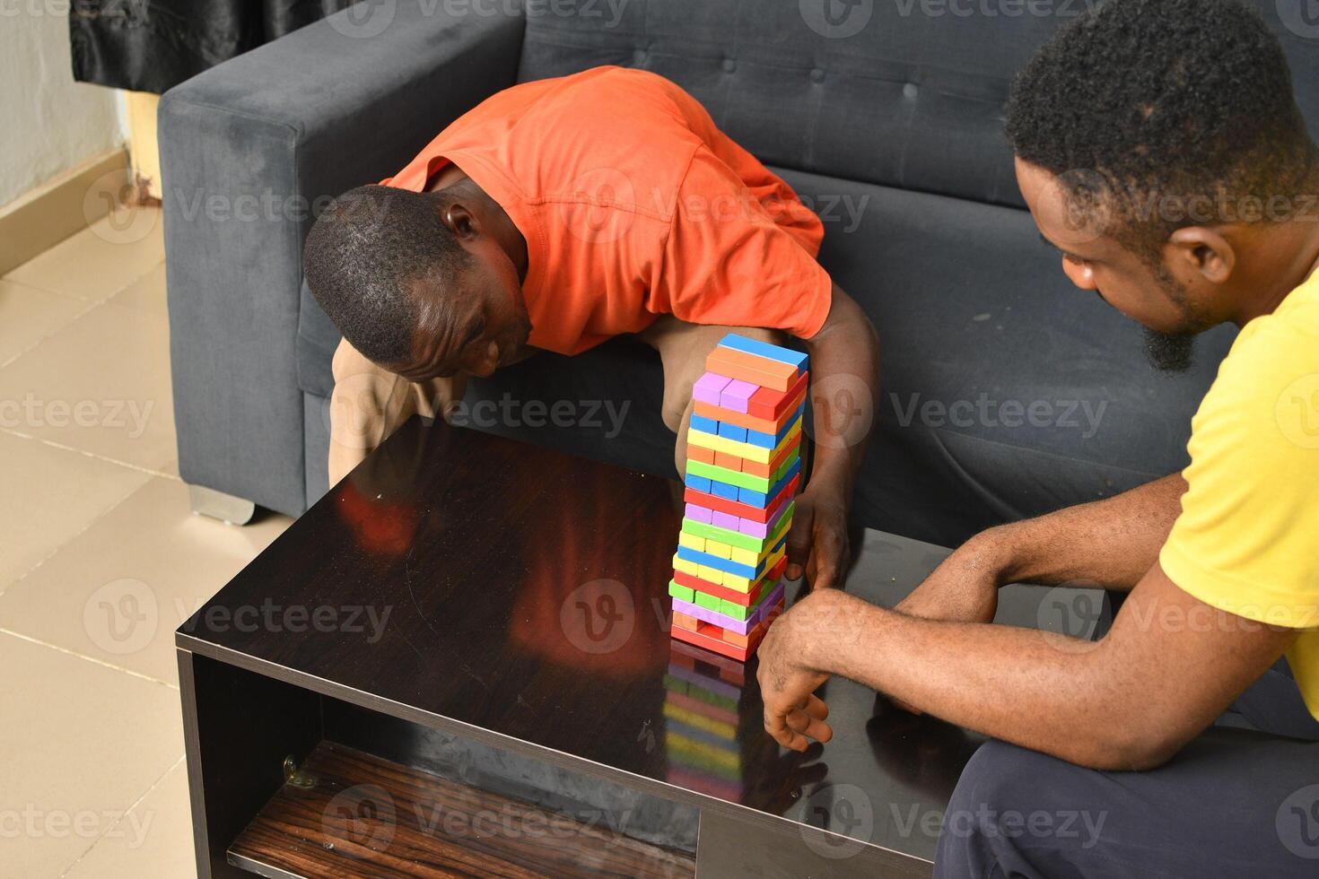 A warm and engaging scene of an amputee man and his friend enjoying a Board game with wooden bricks. Jenga game, wooden tower photo