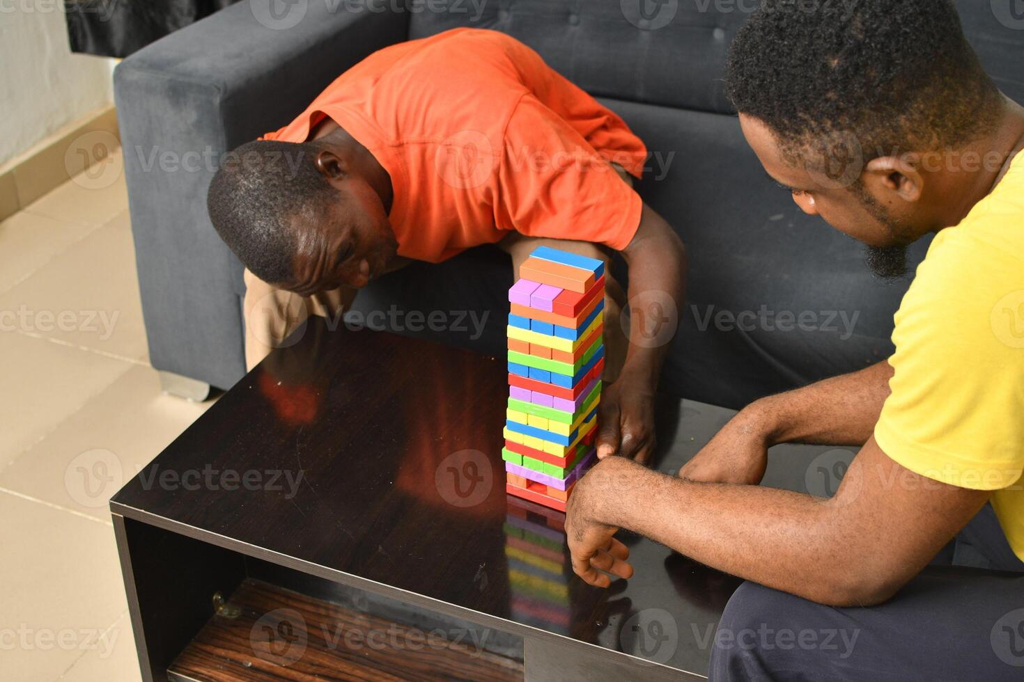 A warm and engaging scene of an amputee man and his friend enjoying a Board game with wooden bricks. Jenga game, wooden tower photo