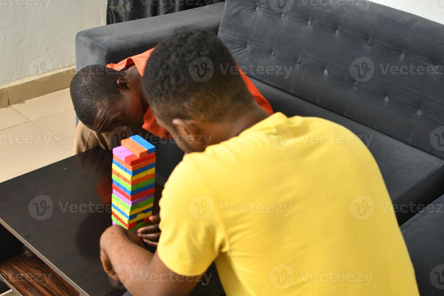 A warm and engaging scene of an amputee man and his friend enjoying a Board game with wooden bricks. Jenga game, wooden tower photo