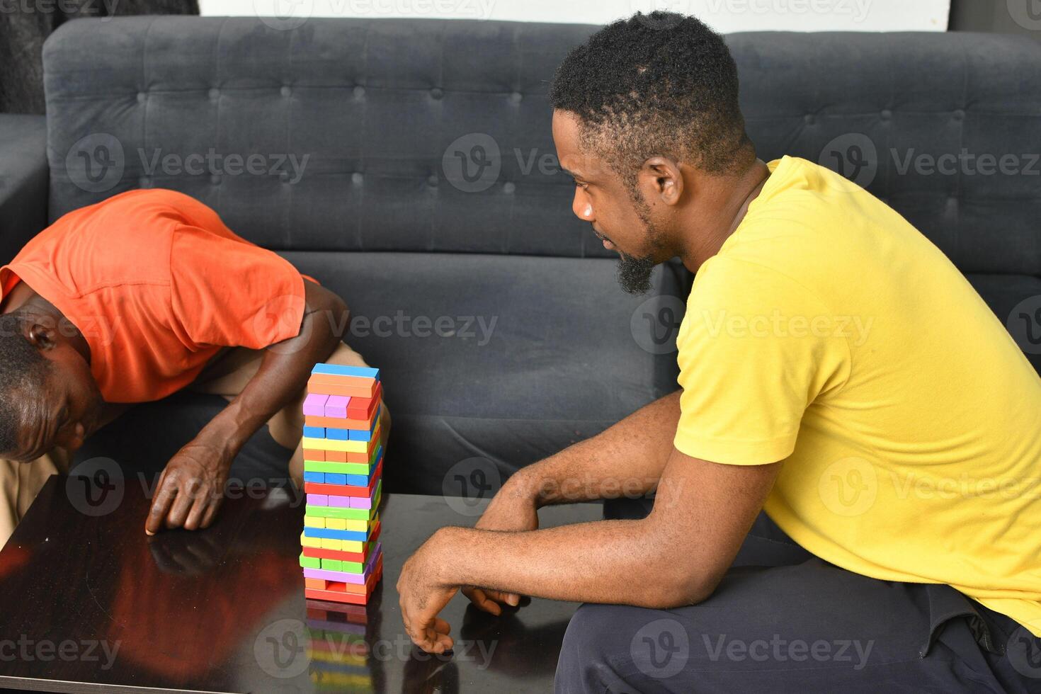 A warm and engaging scene of an amputee man and his friend enjoying a Board game with wooden bricks. Jenga game, wooden tower photo