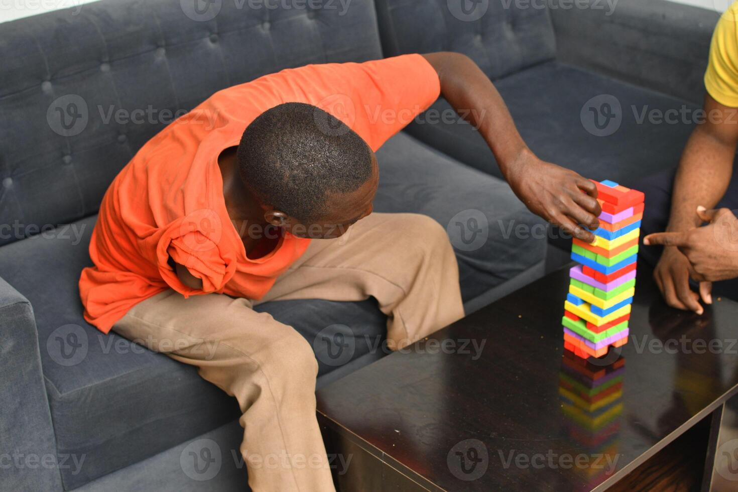 A warm and engaging scene of an amputee man and his friend enjoying a Board game with wooden bricks. Jenga game, wooden tower photo