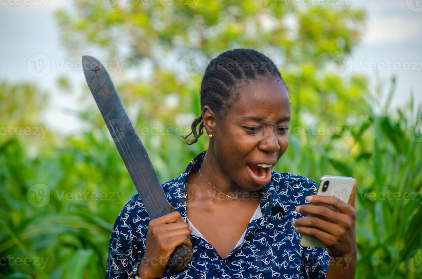 female african farmer using her phone. african farmer checks her mobile phone, texts and chat photo