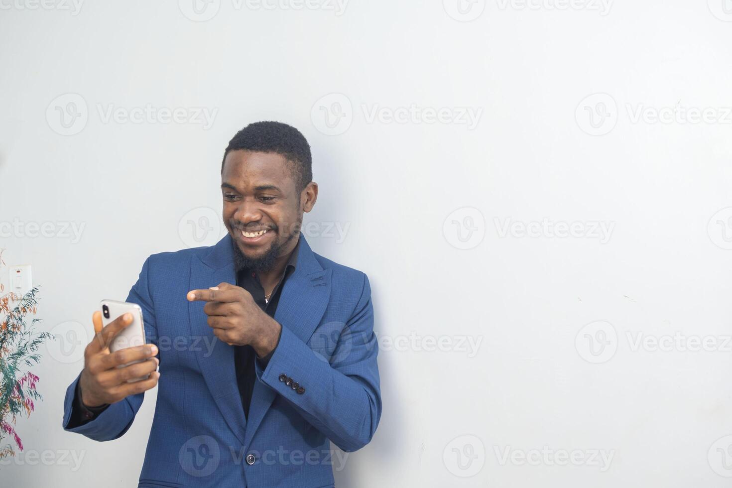 portrait of cheerful young black guy sending message on mobile phone. Happy African-American man using smartphone, enjoying chatting online, messaging in social networks photo