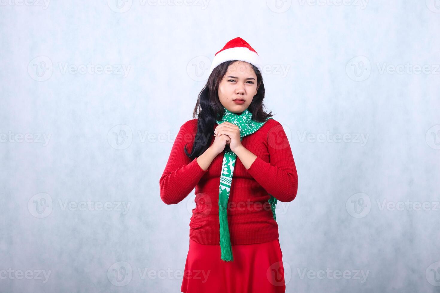 girl charm wearing red sweater party wear with Santa hat and scarf, angry sharp hand clenched fist sign ready to hit, celebrating christmas and new year isolated on white background photo