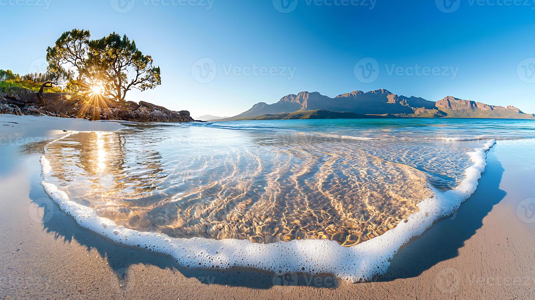 tranquil beach scene with gentle waves lapping at shore, surrounded by mountains and trees, creating serene atmosphere photo