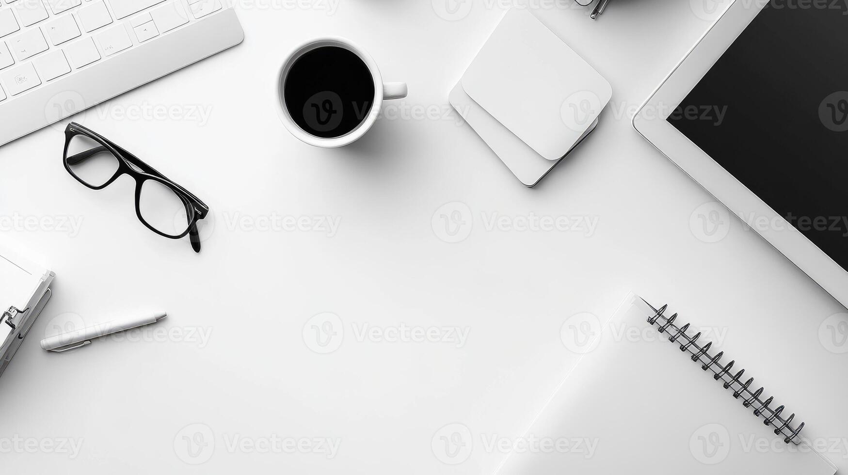 An office desk with a laptop, coffee cup, pen, and other items photo
