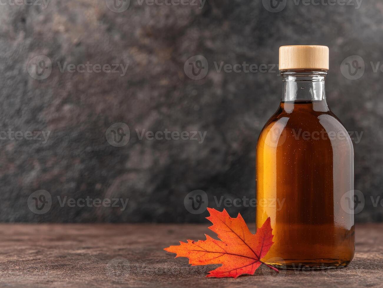 Autumn maple leaf and maple syrup bottle photo