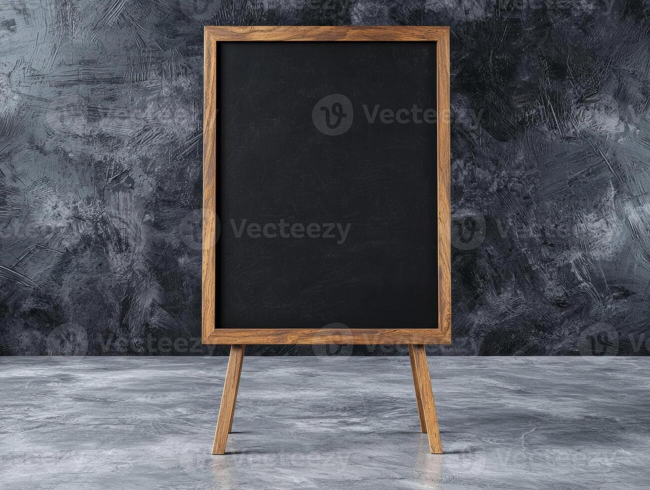 Blank chalkboard on easel in front of textured wall photo
