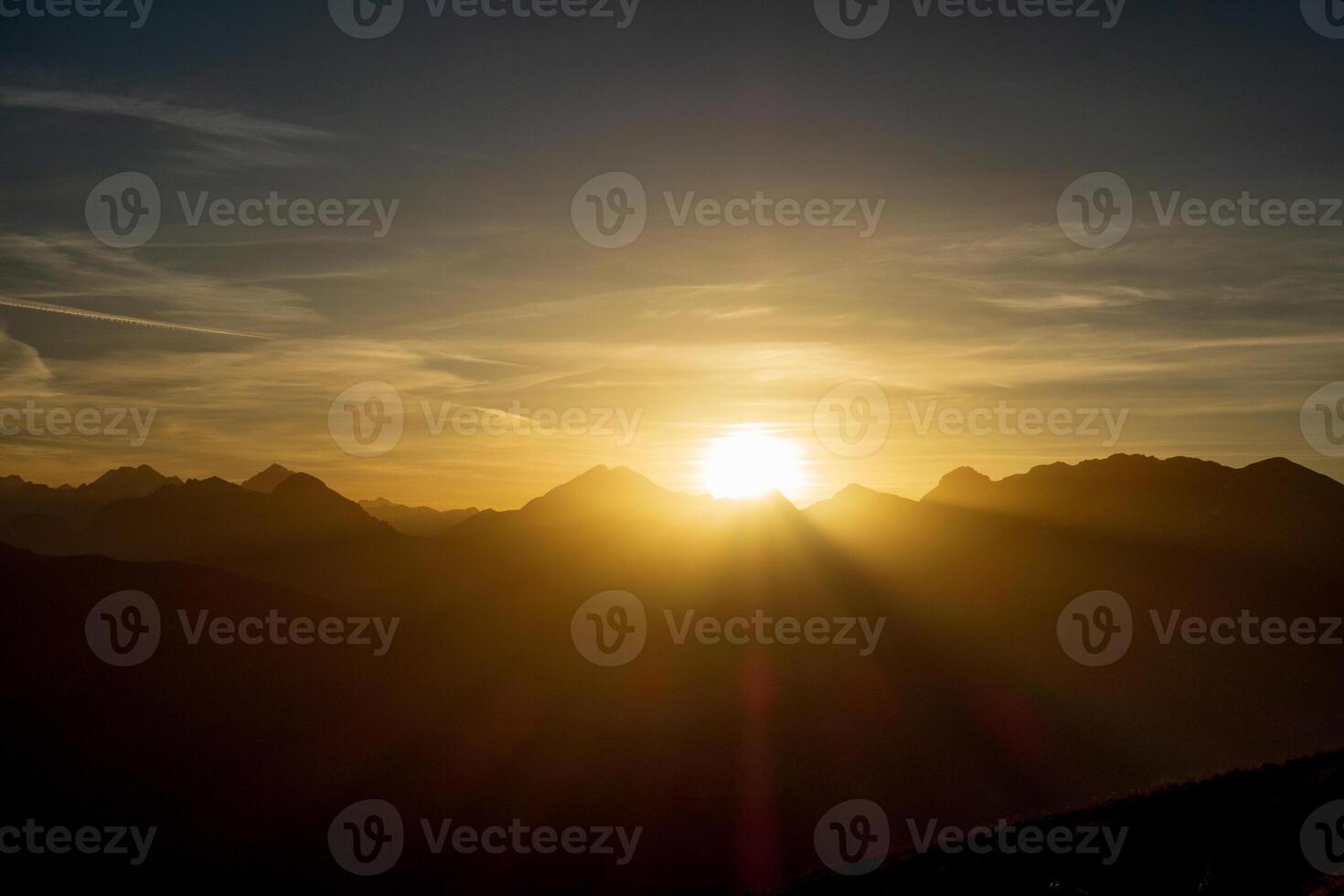 The sun is setting over the mountains in this photo