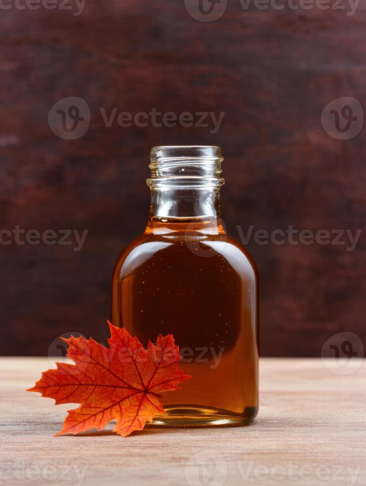 Autumn maple leaf and maple syrup bottle photo