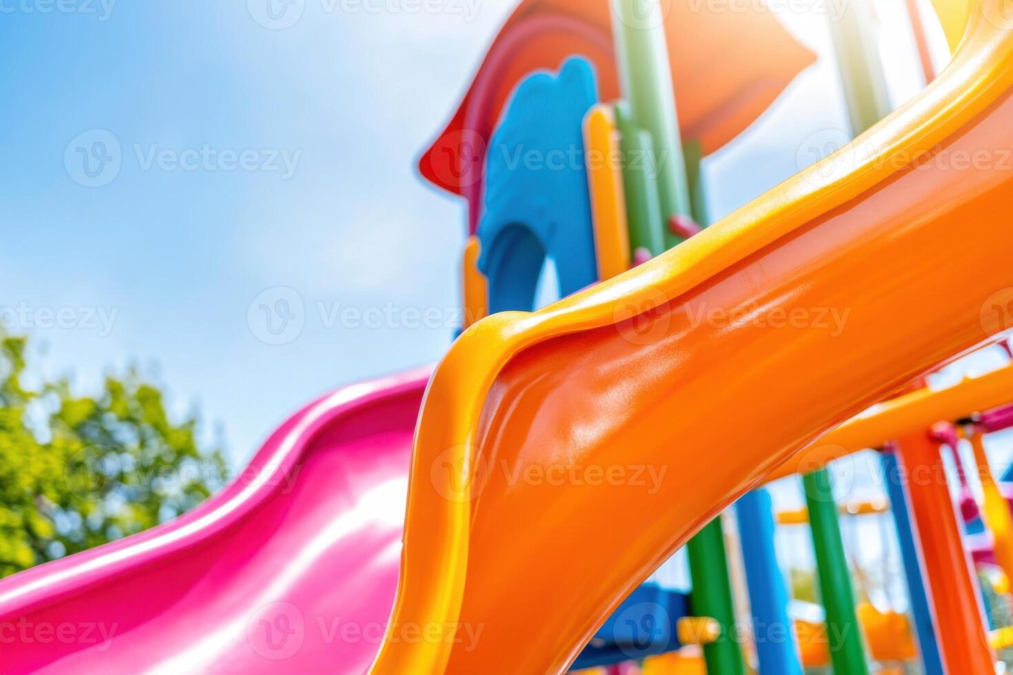 Colorful playground with orange slides, green climbing frames, and pink swings set in a sunny park photo