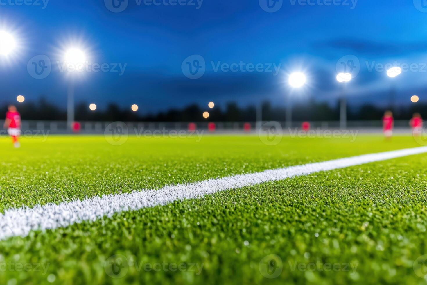 Exciting soccer match under bright stadium lights with players competing in red and blue uniforms against a dark blue sky photo