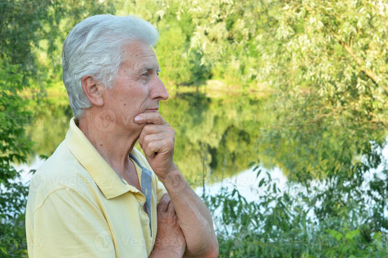 Close up portrait of thinking senior man in park photo
