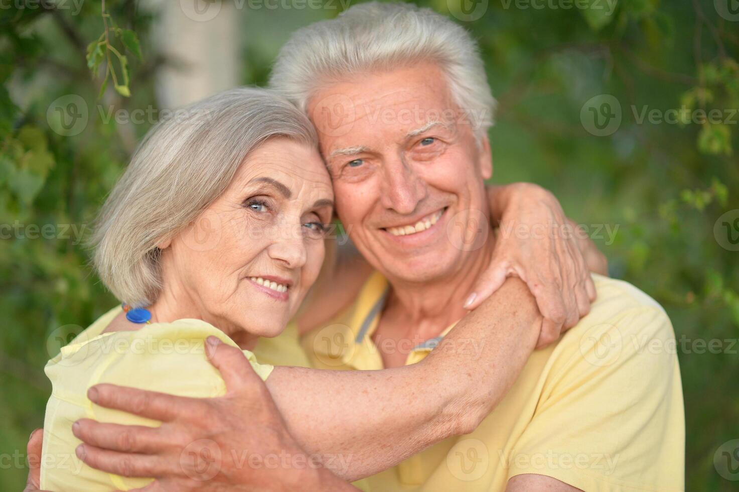 Beautiful senior couple posing and hugging in the park photo