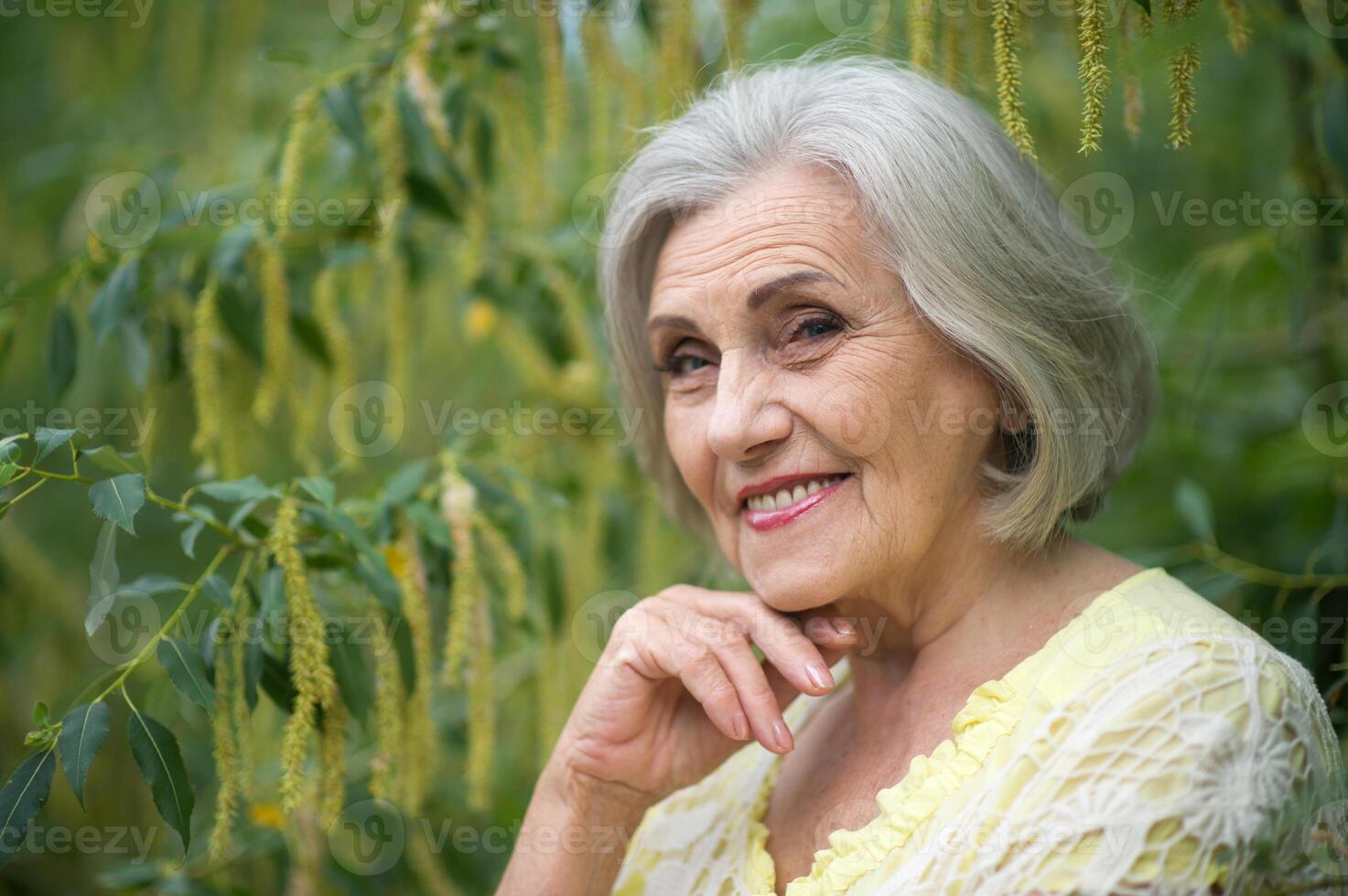 Close up portrait of happy smiling senior woman in park photo