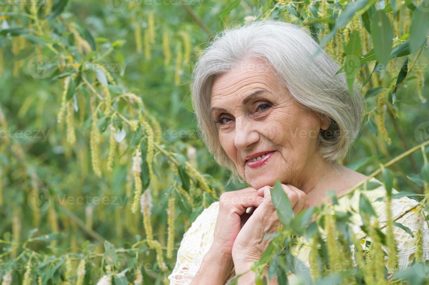 Close up portrait of happy smiling senior woman in park photo