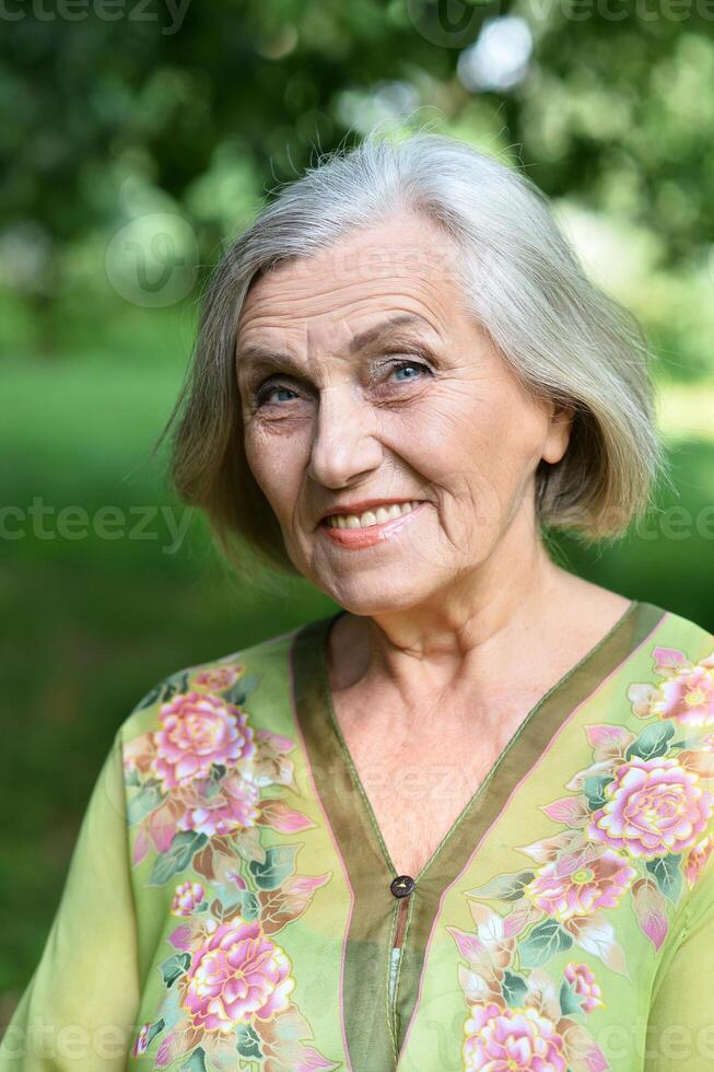 Portrait of a senior woman in summer park photo