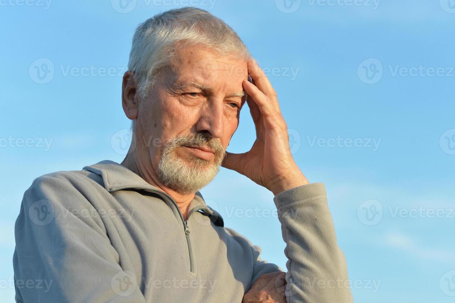 Portrait of a serious senior man on sky background. photo