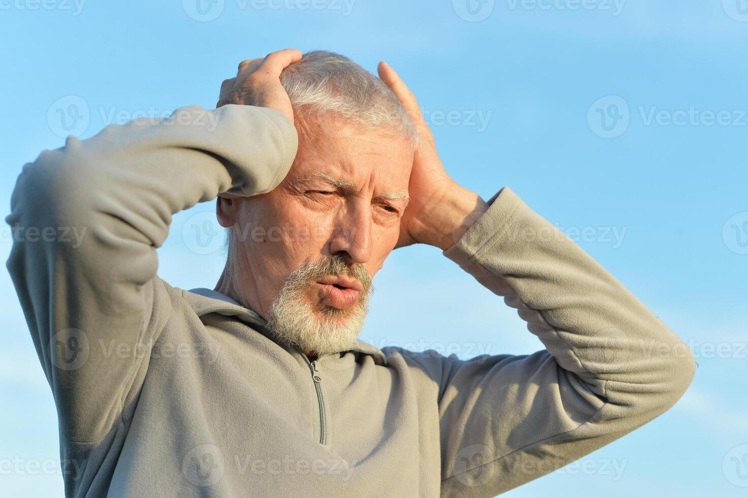 Portrait of a serious senior man on sky background. photo