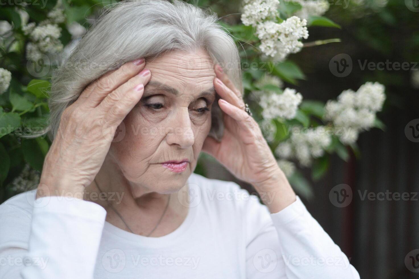 Portrait of senior sad woman in park photo