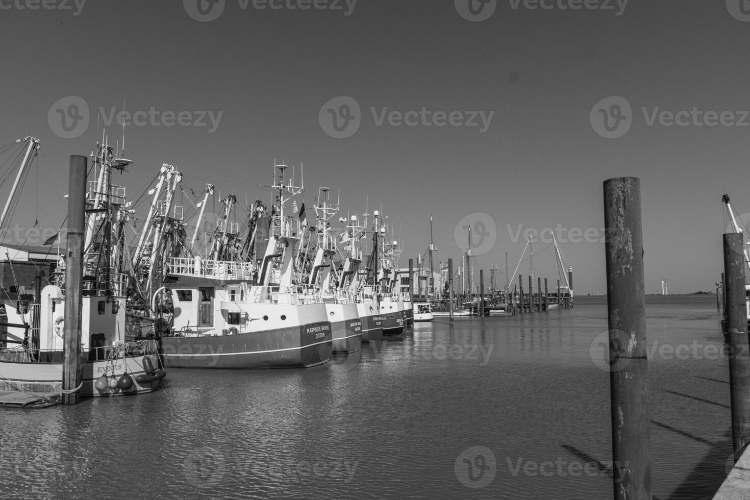 A black and white photo of a dock with boats