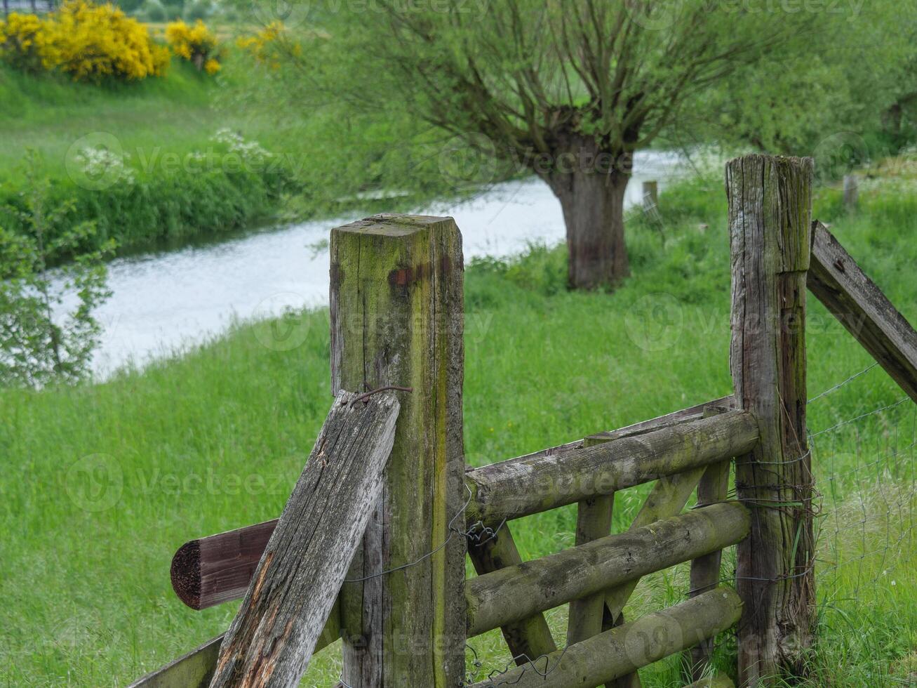 A wooden gate and fence in a field photo
