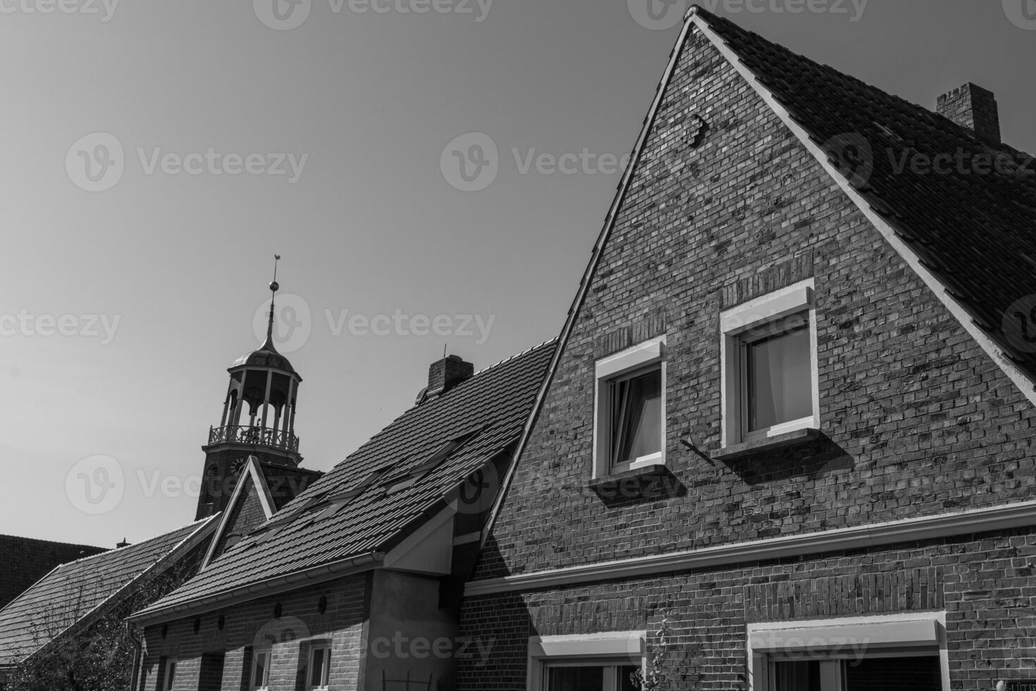 A black and white photo of a clock tower and a building