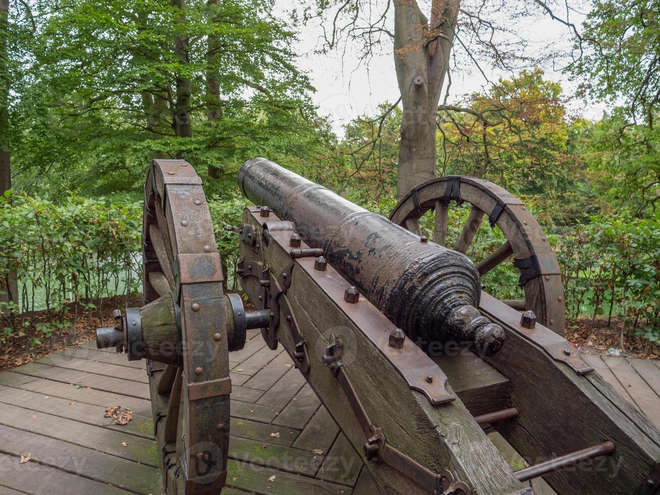 A large cannon on a wooden platform in a park photo