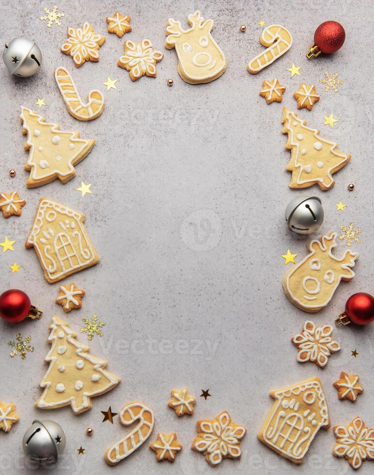 Christmas gingerbread cookies and ornaments creating festive frame on grey background photo