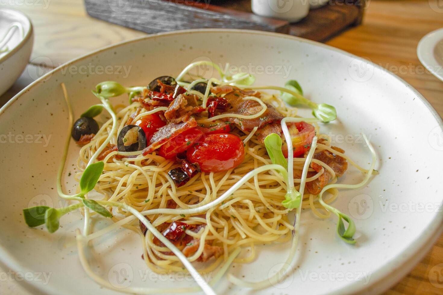 Spaghetti aglio e olio, Traditional Italian Pasta with dried chilli, olive oil and crispy bacon flakes on top photo
