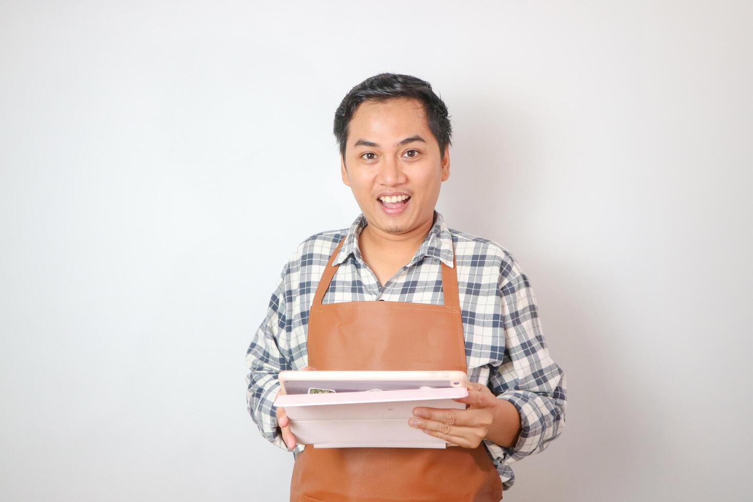 asian men with apron holding tablet and see camera photo