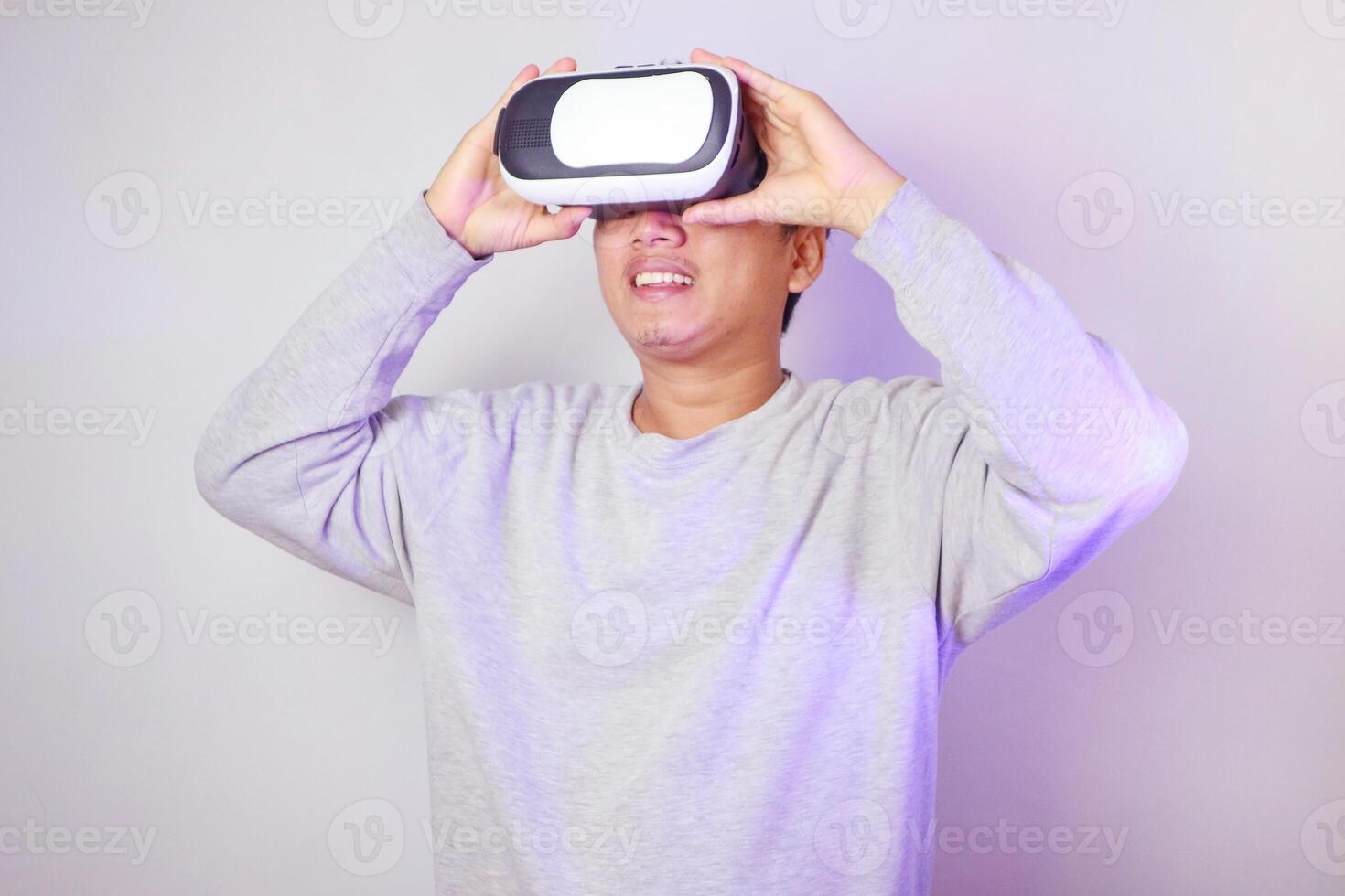 Young man using virtual reality headset, Isolated on gray background studio portrait. photo