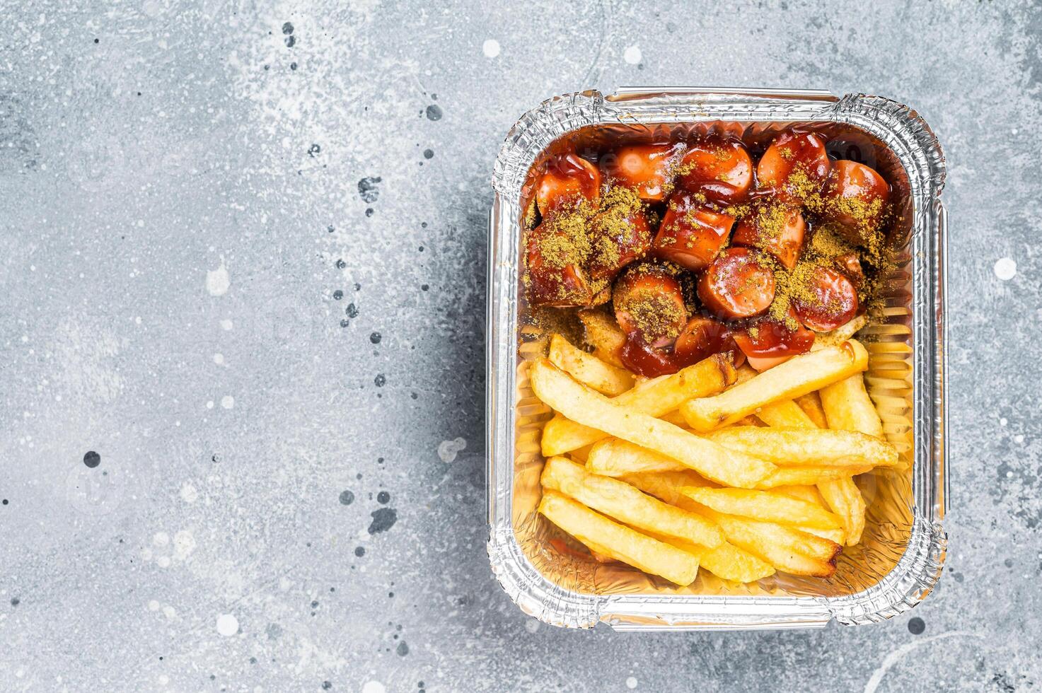 Traditional German currywurst with french fry served take away. Gray background. Top view. Copy space photo