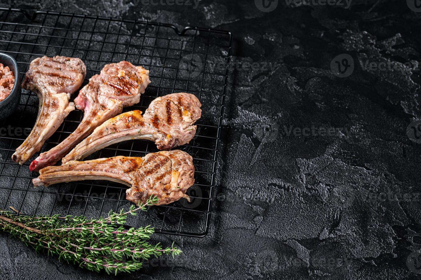 Barbecue Grilled lamb meat chops, mutton cutlets. Black background. Top view. Copy space photo