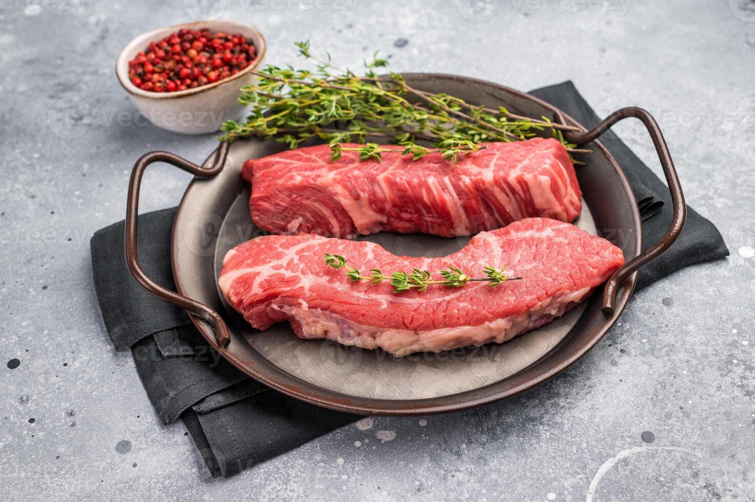 Raw Tri Tip Steak from Black Angus beef meat in stell tray. grey background. top view photo