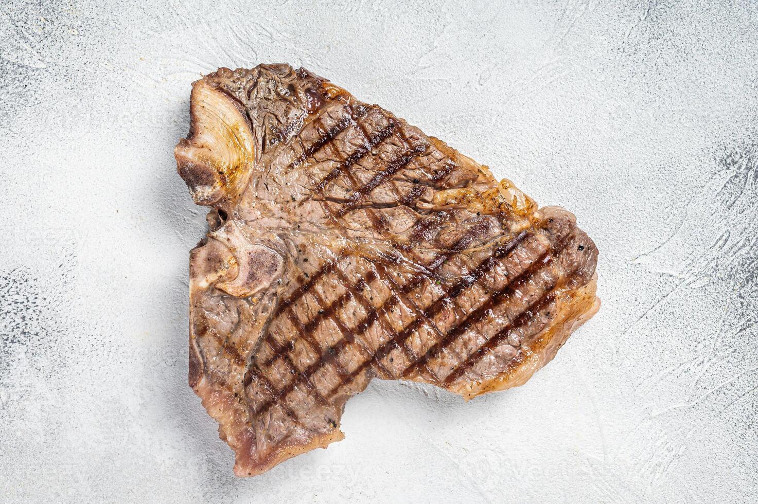Grilled T-bone or Porterhouse beef meat Steak. White background. Top view. Copy space photo