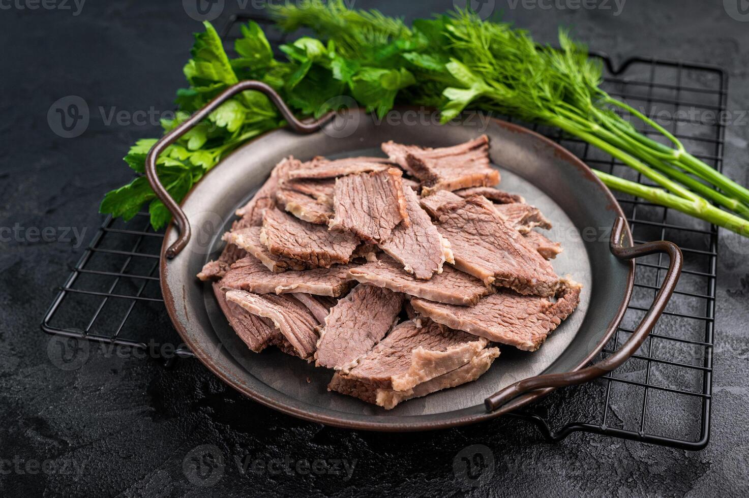 Boiled sliced beef meat in a steel tray. black background. top view photo