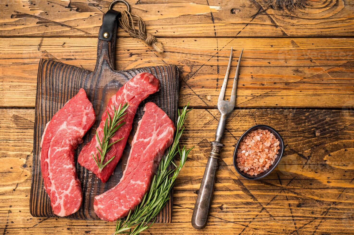 Raw marbled beef Steak, beef meat on wooden board with herbs. wooden background. top view photo