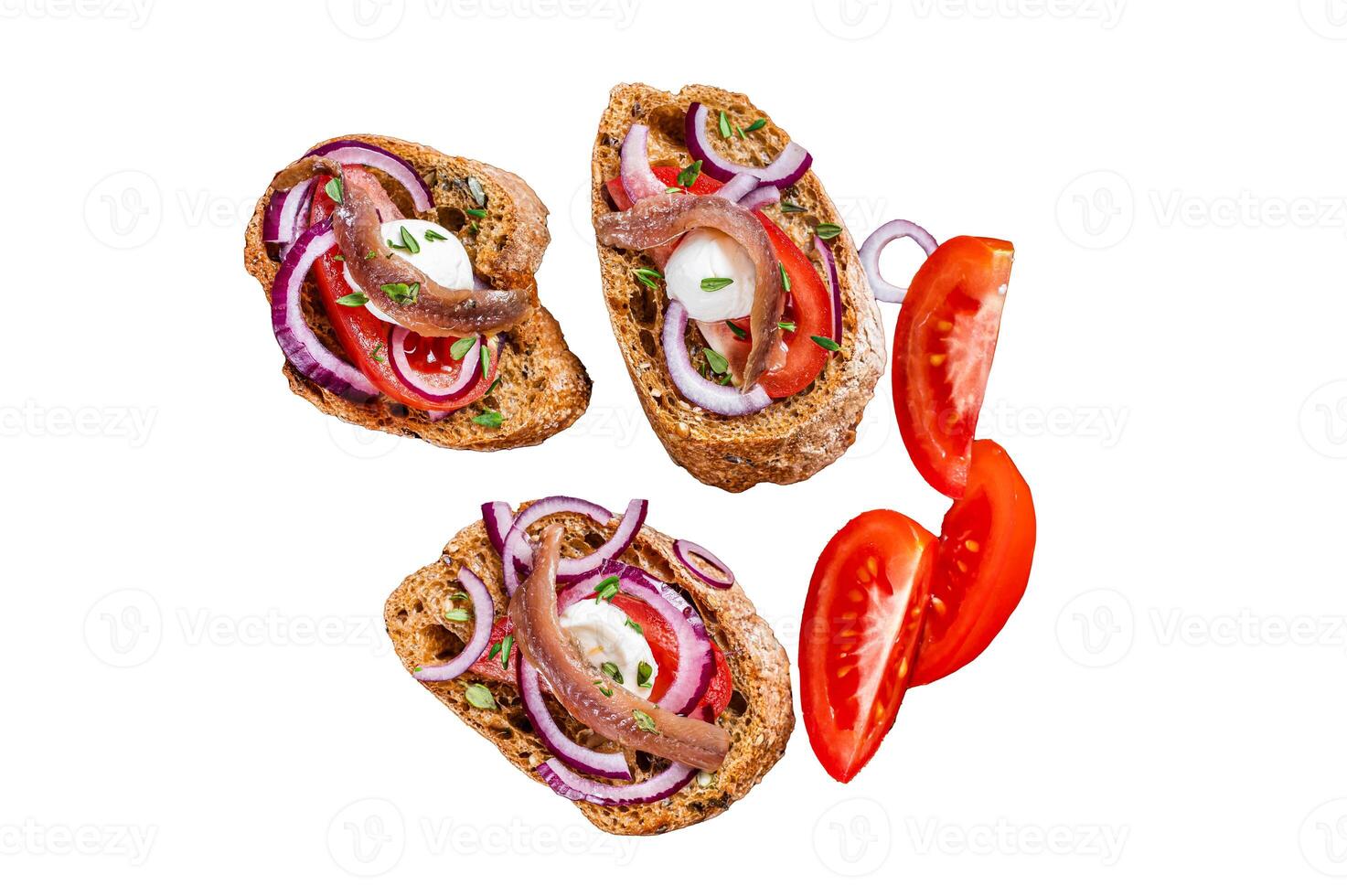 Spanish tapas on bread with olive oil, herbs, tomatoes and spicy anchovy fillets. Isolated on white background, top view. photo