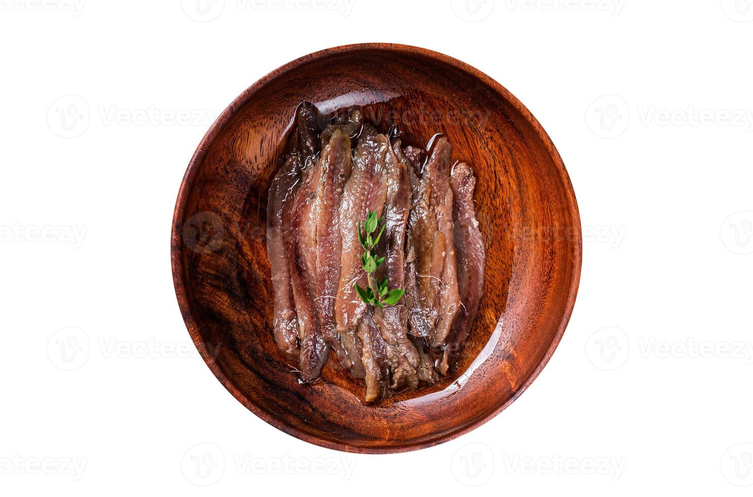 Canned Anchovies fish fillet in a wooden bowl. Isolated on white background. photo