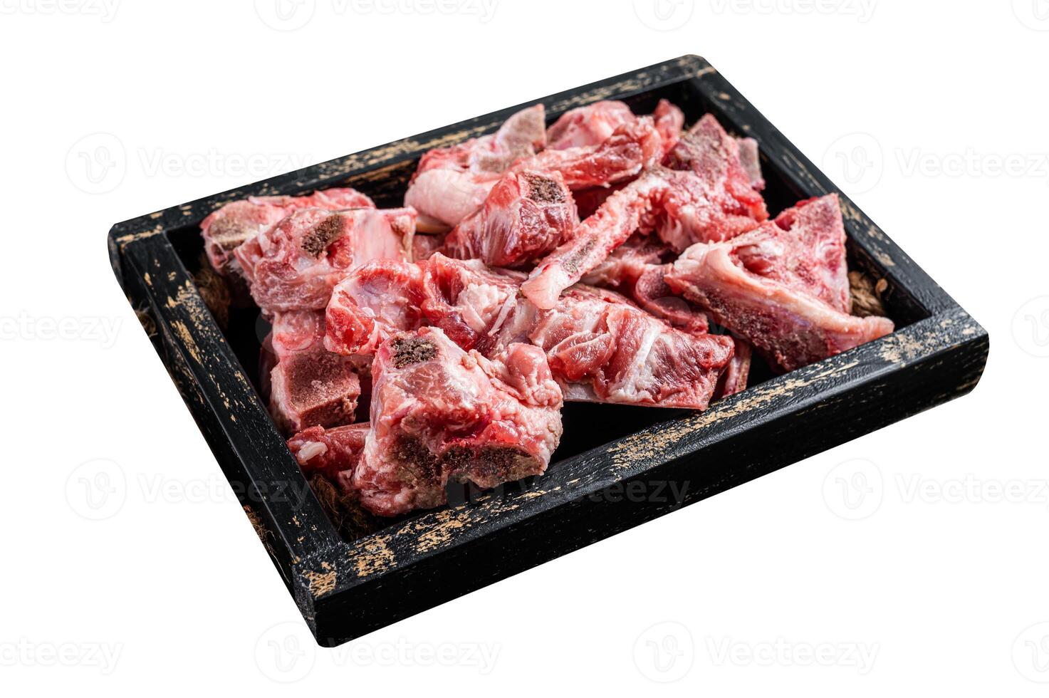 Raw diced meat with bone in a wooden tray. Isolated on white background. Top view. photo
