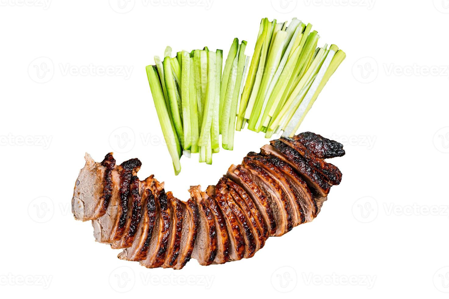 Sliced Peking Duck served with cucumber, green onion, and wheaten chinese pancakes on a meat cleaver. Isolated, white background. photo