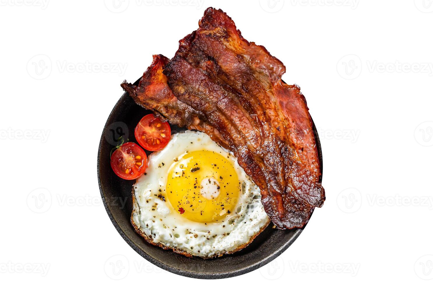 English breakfast with fried egg and bacon in cast iron pan. Isolated, white background. Top view. photo