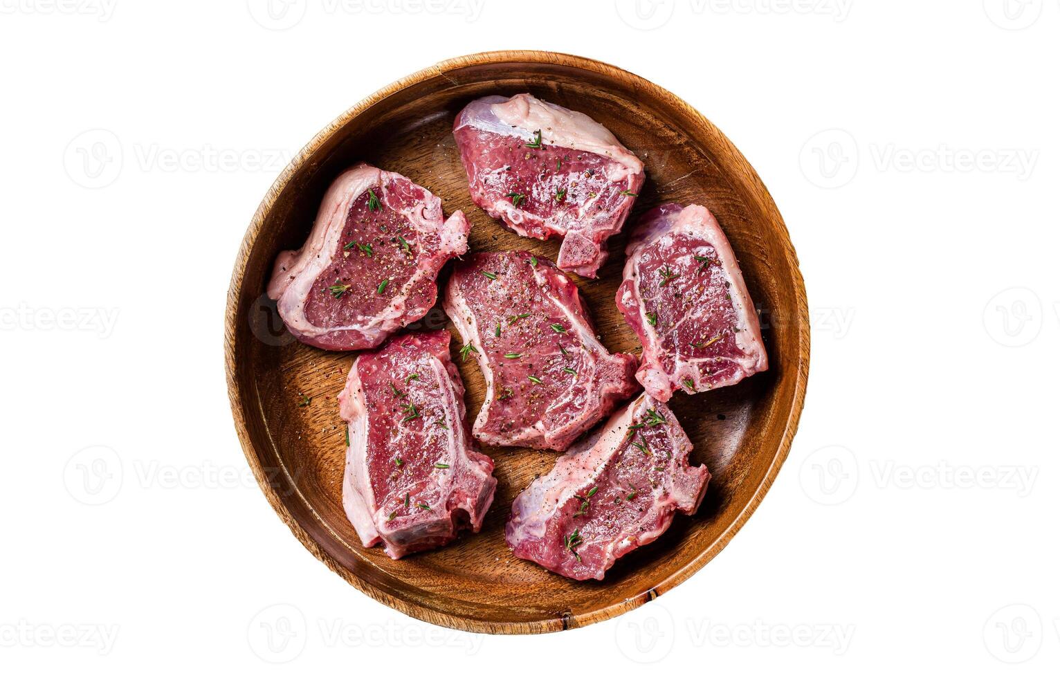 Raw lamb loin rib chops steaks in wooden plate with herbs. Isolated on white background. photo