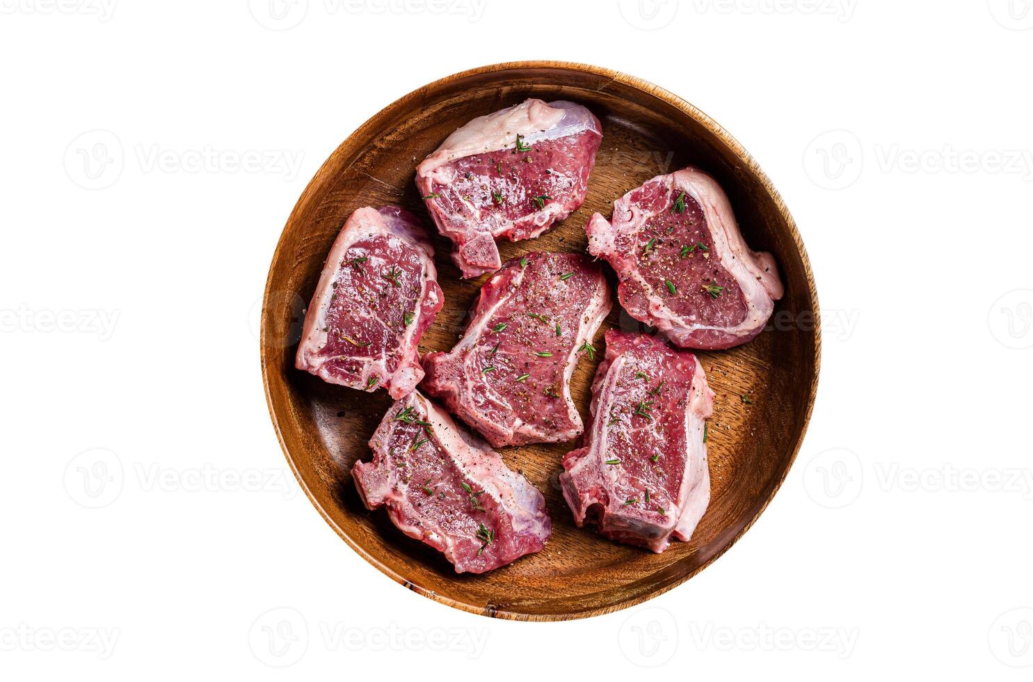 Raw lamb loin rib chops steaks in wooden plate with herbs. Isolated, white background. Top view. photo