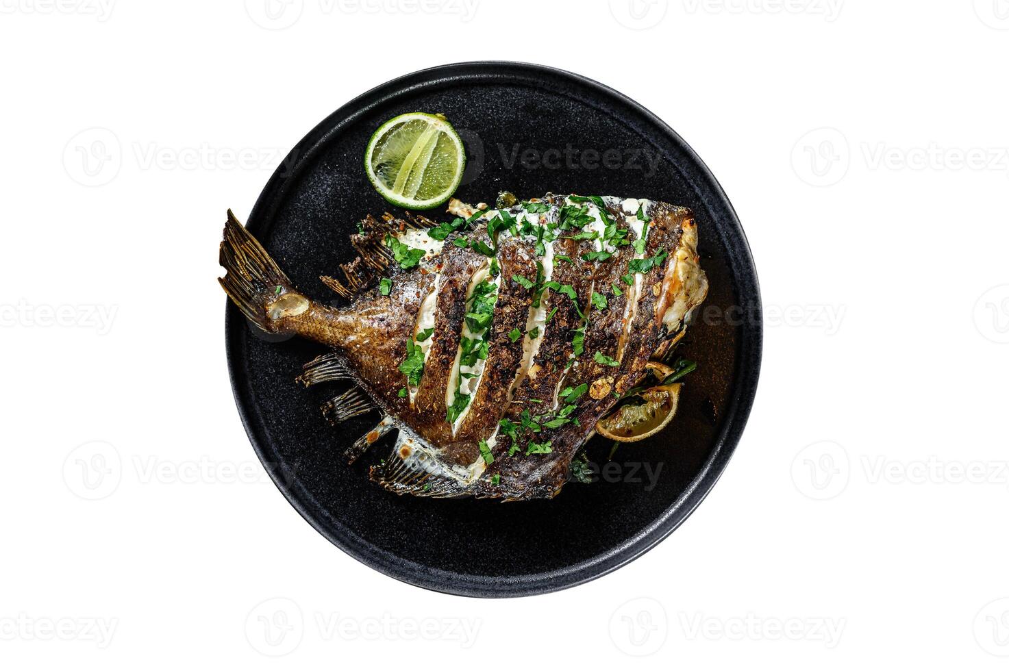 Fried Dory fish with lime and parsley in a pan. Vegatarian health food. Isolated on white background. photo