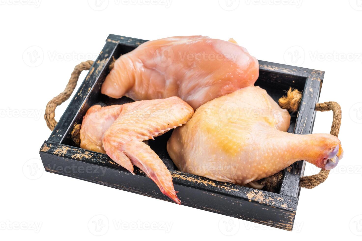 Raw chicken pieces in a wooden tray, ready for cooking photo