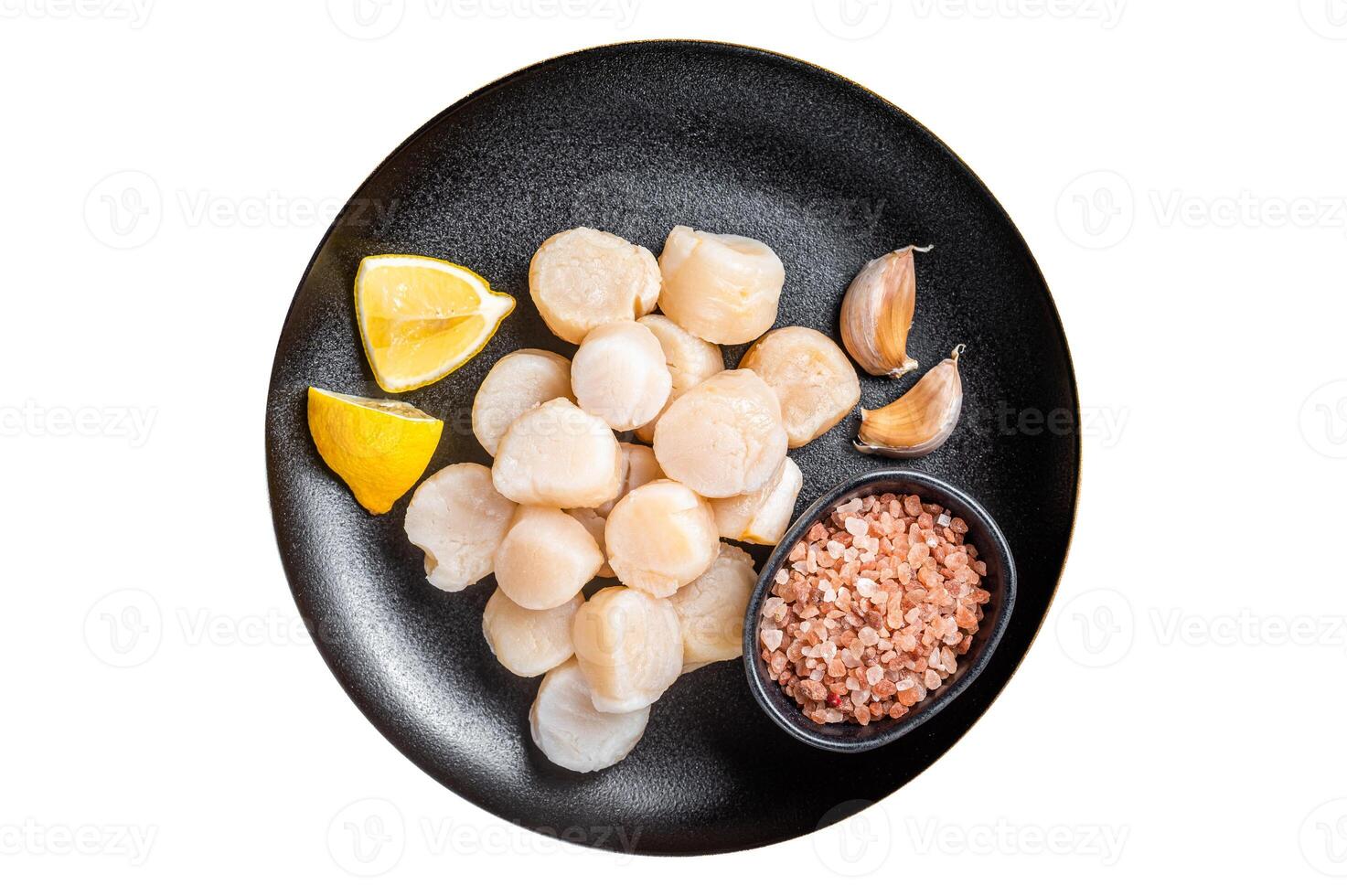 Raw sea scallops seafood on a plate with pink salt and lemon. Isolated on white background. photo