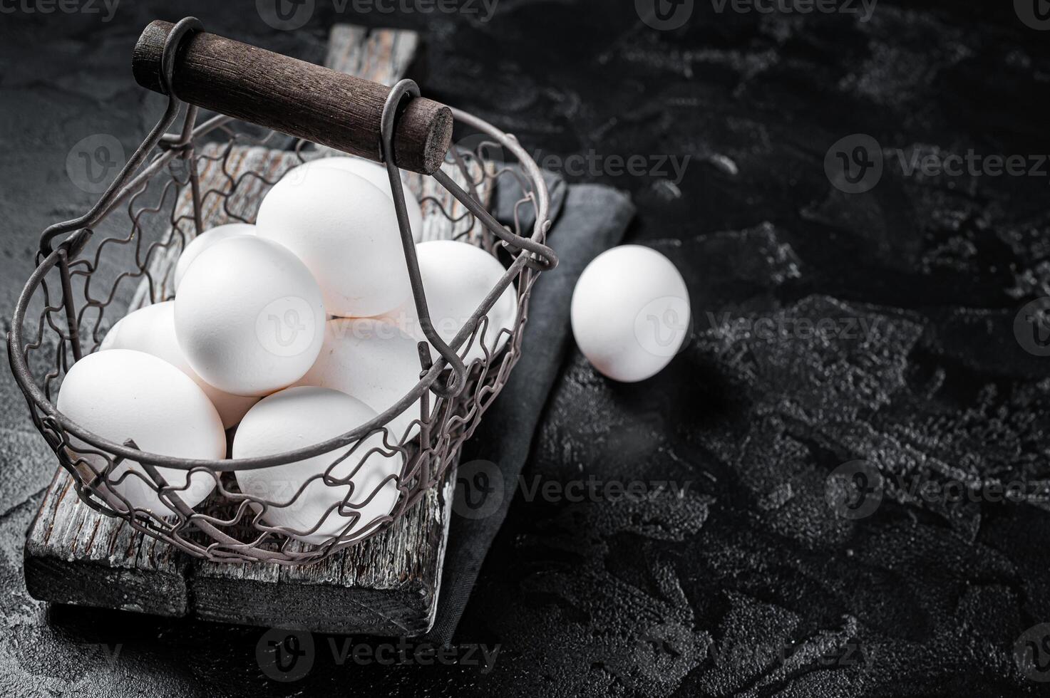 Basket with white chicken eggs. Black background. Top view. Copy space photo