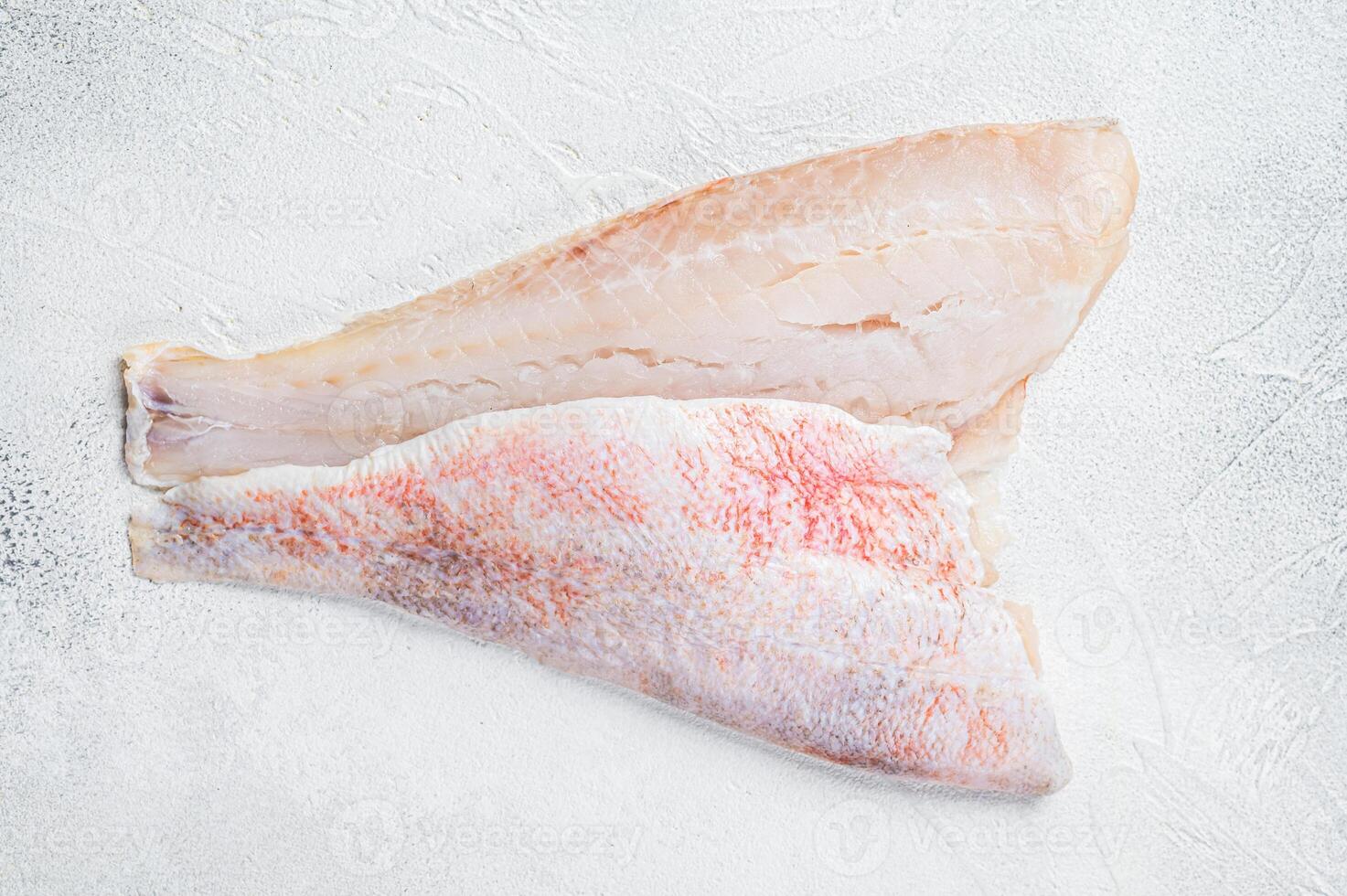 Raw red perch fillet, redfish fish meat. White background. Top view. Copy space photo
